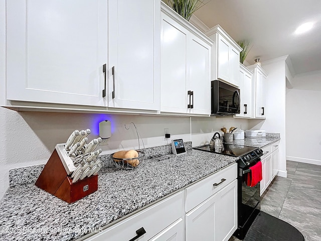 kitchen featuring baseboards, white cabinets, ornamental molding, light stone countertops, and black appliances