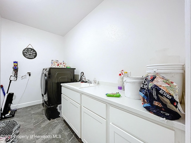 laundry room featuring washer and clothes dryer, a sink, cabinet space, and baseboards