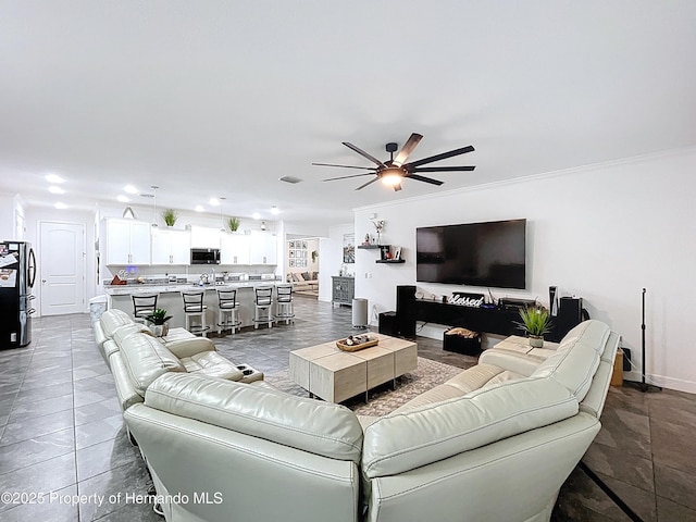 living room with ornamental molding, recessed lighting, baseboards, and a ceiling fan