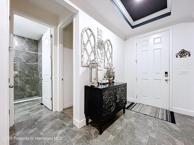 foyer entrance with marble finish floor, ornamental molding, and baseboards