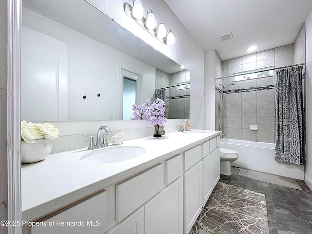 bathroom featuring double vanity, shower / bath combo, a sink, and toilet