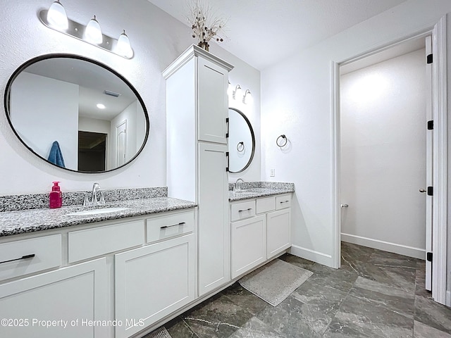 bathroom featuring two vanities, a sink, visible vents, and baseboards