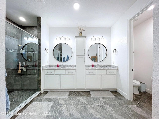 full bathroom with toilet, a stall shower, baseboards, and vanity