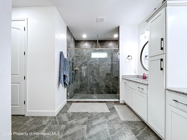 bathroom with a stall shower, baseboards, visible vents, a textured ceiling, and vanity