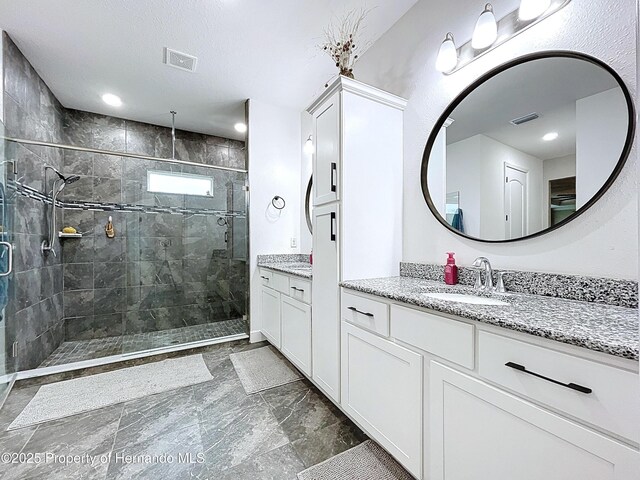 full bath featuring a stall shower, visible vents, and vanity