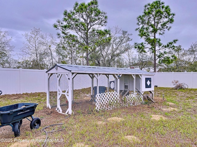 view of yard featuring an outdoor structure, a fenced backyard, and exterior structure