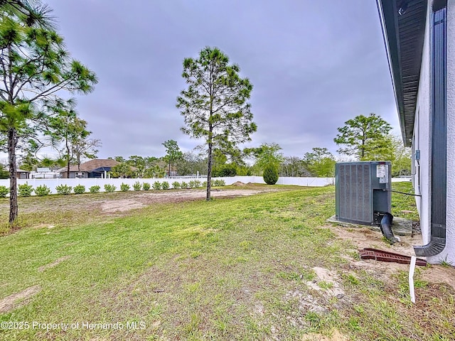 view of yard featuring fence and central air condition unit