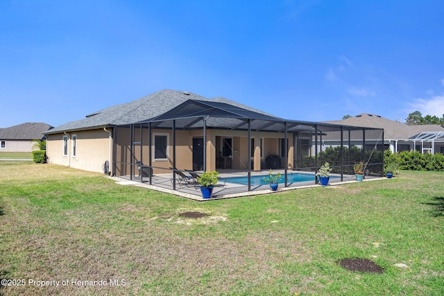 rear view of property with a lawn, a patio area, a lanai, and an outdoor pool