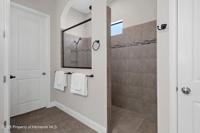 full bathroom with tile patterned flooring, baseboards, and walk in shower