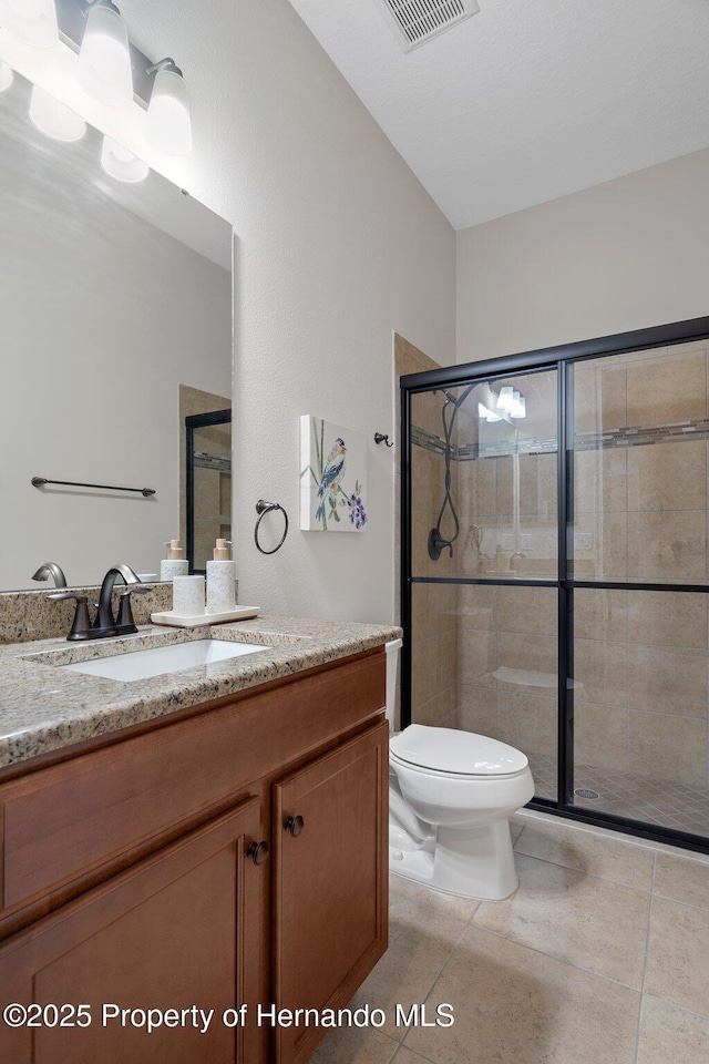 bathroom featuring a stall shower, visible vents, vanity, and toilet