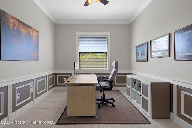 office area featuring a wainscoted wall, ceiling fan, crown molding, a decorative wall, and light tile patterned flooring