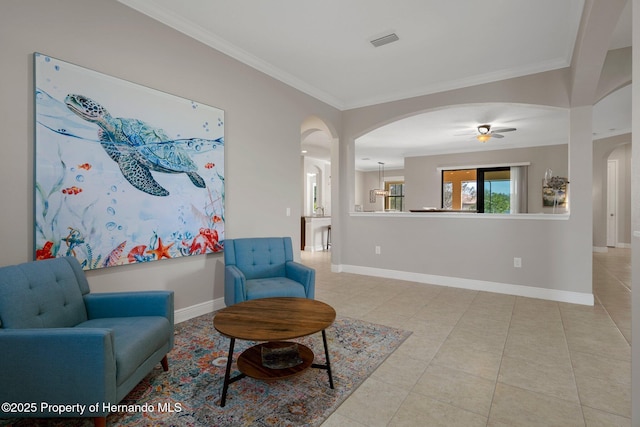 sitting room with arched walkways, visible vents, baseboards, tile patterned floors, and crown molding