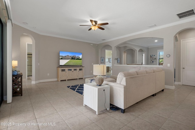 living room featuring light tile patterned floors, baseboards, visible vents, and crown molding