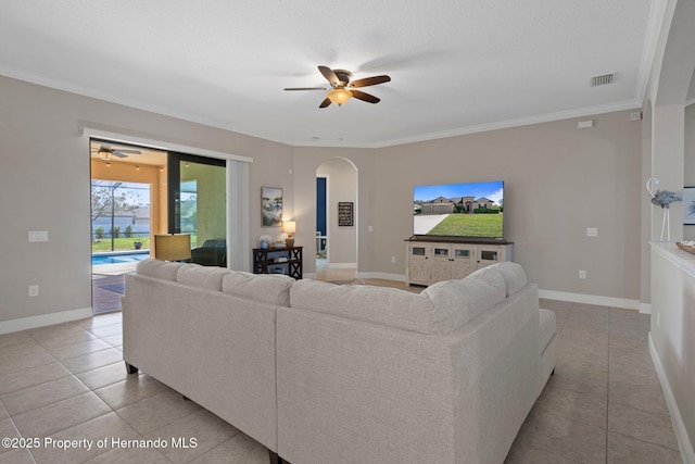 living room featuring baseboards, crown molding, and light tile patterned flooring