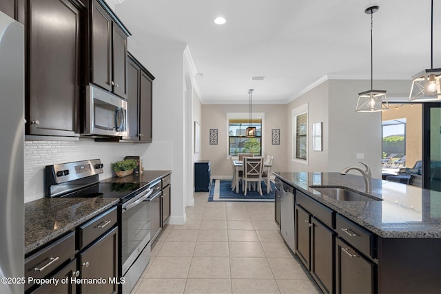 kitchen featuring light tile patterned floors, decorative backsplash, appliances with stainless steel finishes, crown molding, and a sink