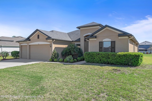 view of front facade with a garage, driveway, a front lawn, and stucco siding