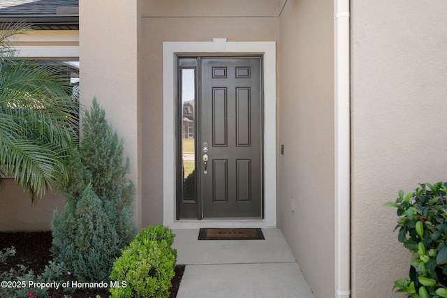 doorway to property featuring stucco siding