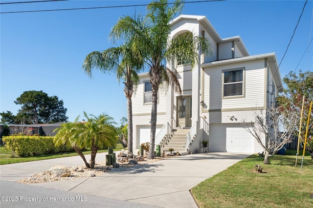 view of front facade featuring a front yard, concrete driveway, an attached garage, and stucco siding