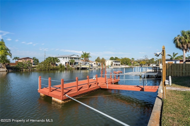 view of dock featuring a water view and fence