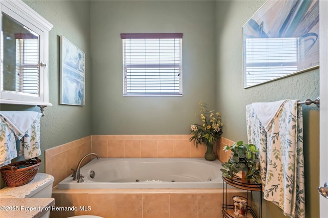 full bathroom featuring a whirlpool tub and a textured wall