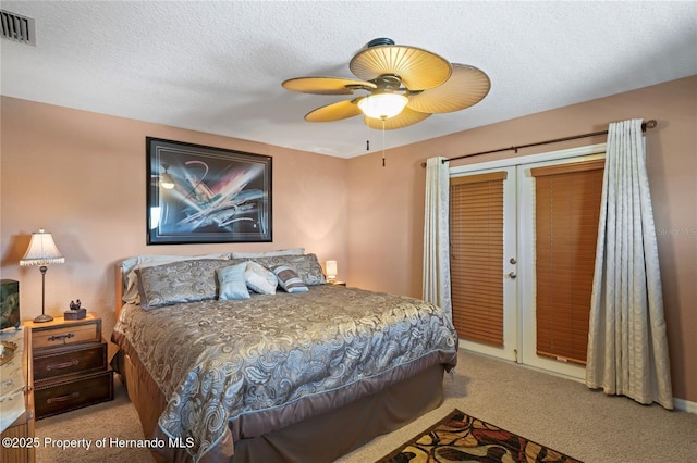 bedroom featuring light carpet, visible vents, ceiling fan, a textured ceiling, and a closet