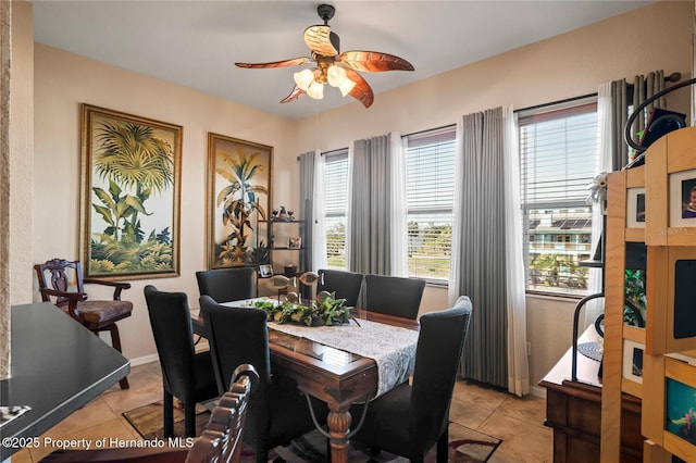 dining room with baseboards, a ceiling fan, and light tile patterned flooring