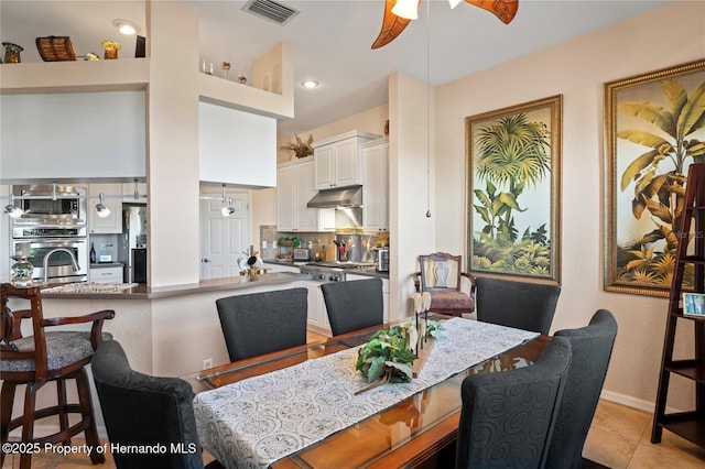 dining space with visible vents, ceiling fan, baseboards, and light tile patterned floors