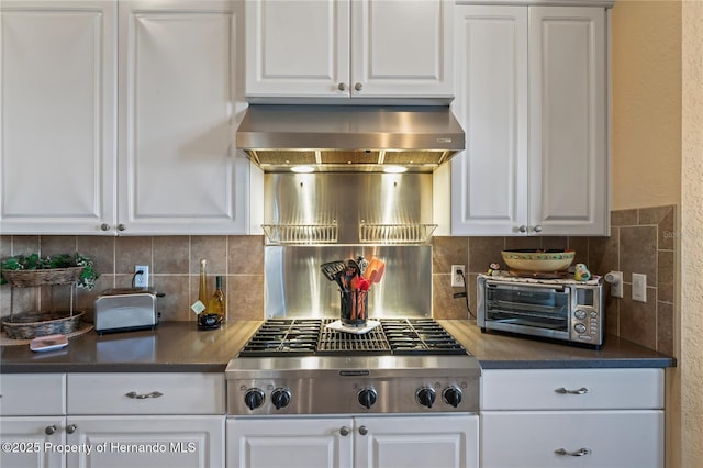 kitchen with a toaster, white cabinets, stainless steel gas stovetop, and extractor fan