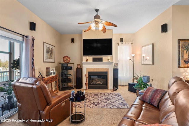 living area with a ceiling fan, carpet, and a fireplace