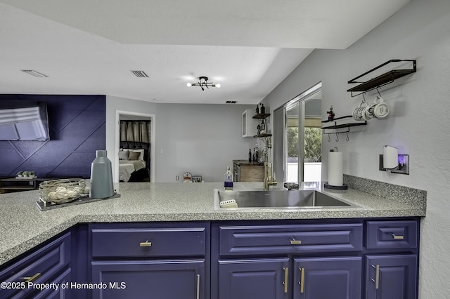 kitchen featuring blue cabinets, visible vents, and a sink