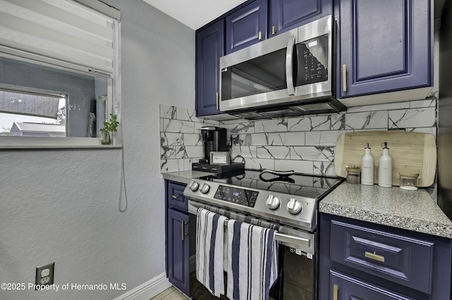 kitchen with blue cabinets, stainless steel appliances, backsplash, and light countertops