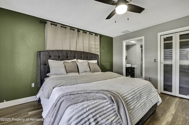 bedroom with baseboards, visible vents, ceiling fan, wood finished floors, and access to outside