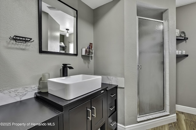 bathroom with visible vents, a textured wall, marble finish floor, vanity, and a shower stall