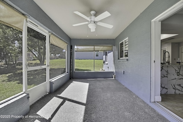 unfurnished sunroom with a ceiling fan