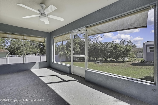 unfurnished sunroom featuring a ceiling fan