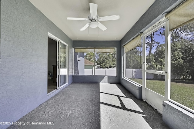 unfurnished sunroom featuring ceiling fan