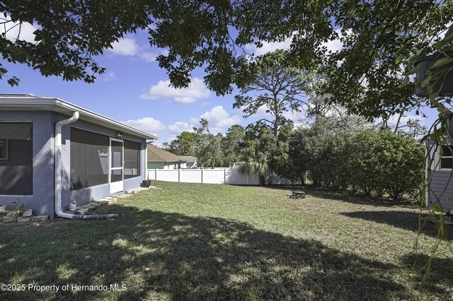 view of yard featuring fence and a sunroom