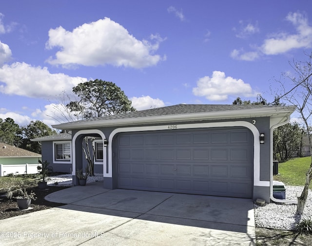 ranch-style home featuring a garage, driveway, and stucco siding