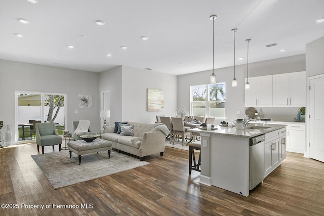 kitchen with dark wood-type flooring, white cabinets, and stainless steel dishwasher