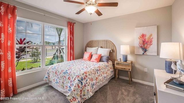 carpeted bedroom featuring multiple windows, a ceiling fan, and baseboards