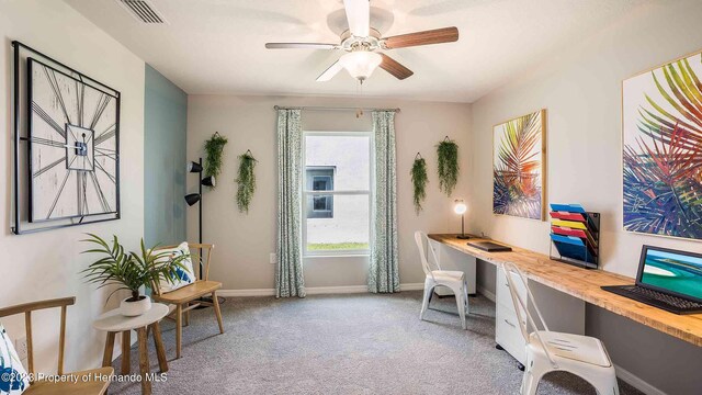 office space with baseboards, visible vents, a ceiling fan, light colored carpet, and built in study area