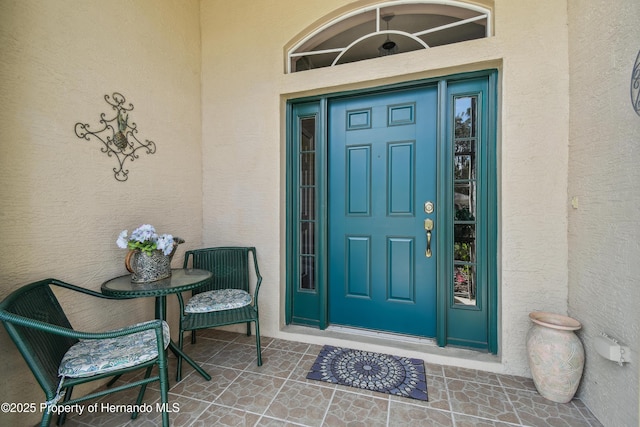 property entrance with stucco siding