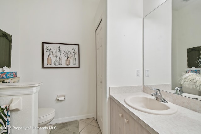 bathroom featuring baseboards, vanity, toilet, and tile patterned floors