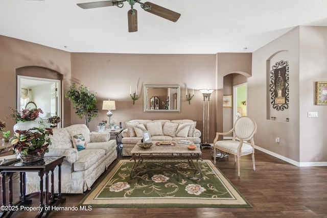 living area with a ceiling fan, baseboards, and wood finished floors