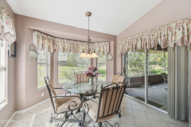 dining room with lofted ceiling, baseboards, and light tile patterned flooring