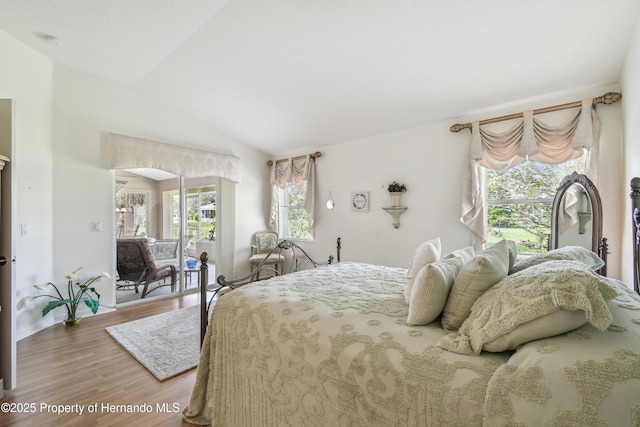 bedroom with vaulted ceiling and wood finished floors