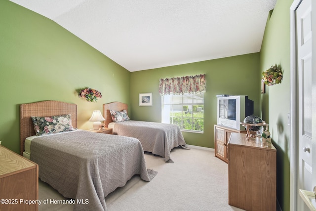 bedroom featuring lofted ceiling, baseboards, and light colored carpet