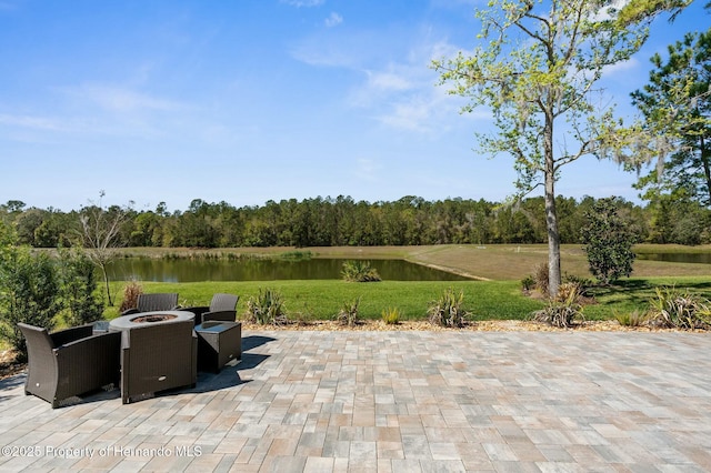 view of patio with a water view and a fire pit