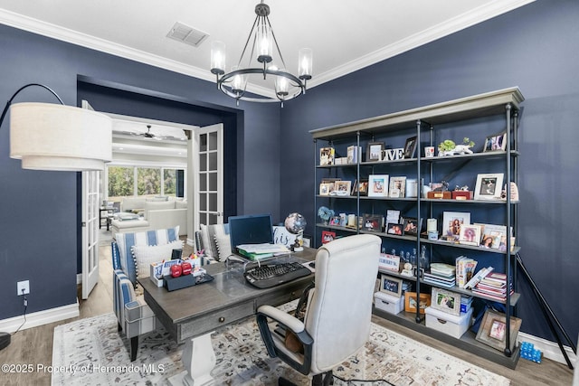 home office featuring visible vents, baseboards, wood finished floors, an inviting chandelier, and crown molding