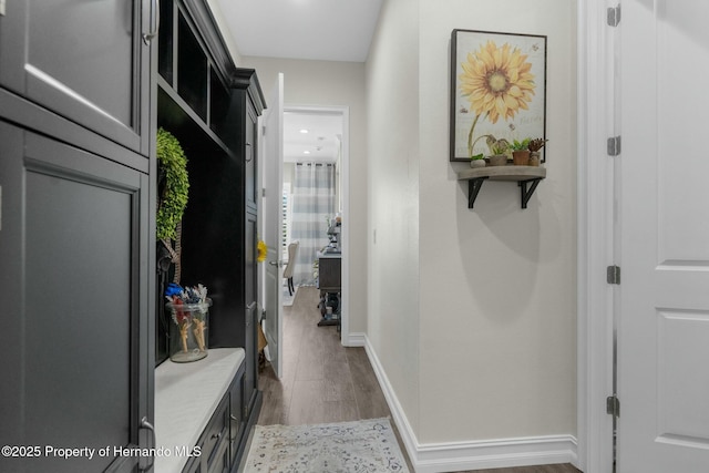 mudroom with baseboards and wood finished floors